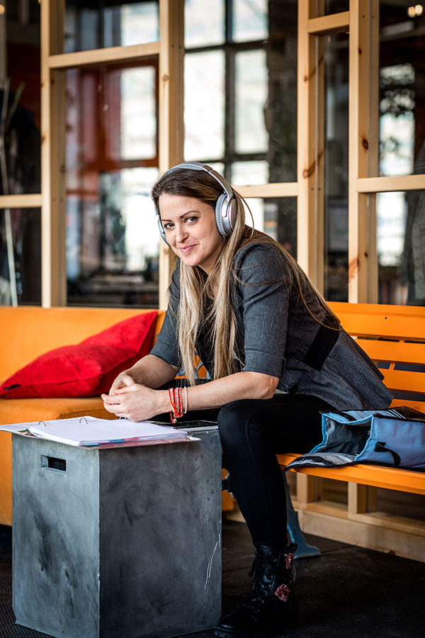 Woman wearing headphones in front of an open binder